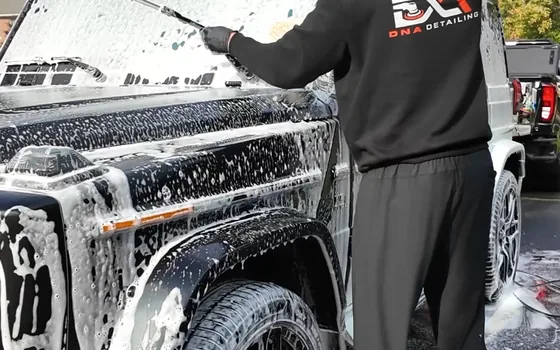 Andrew working the foamed side of a G63 in a driveway