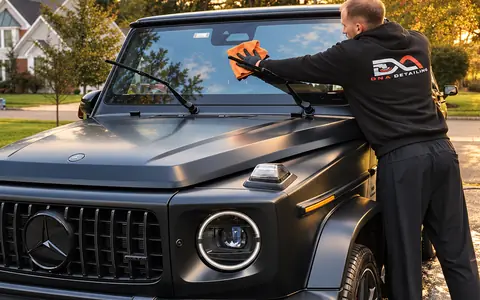 Andrew working the hood of a matte black G63 by hand